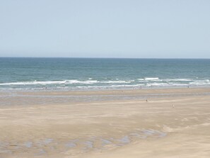 A wide beach with a clear view of the ocean and a sandy shore. - Too Hoots (Dulas)