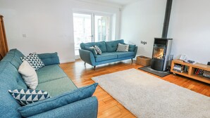 Ein Wohnzimmer mit einer Couch, einem Teppich, einem Bücherregal und einem Kamin.