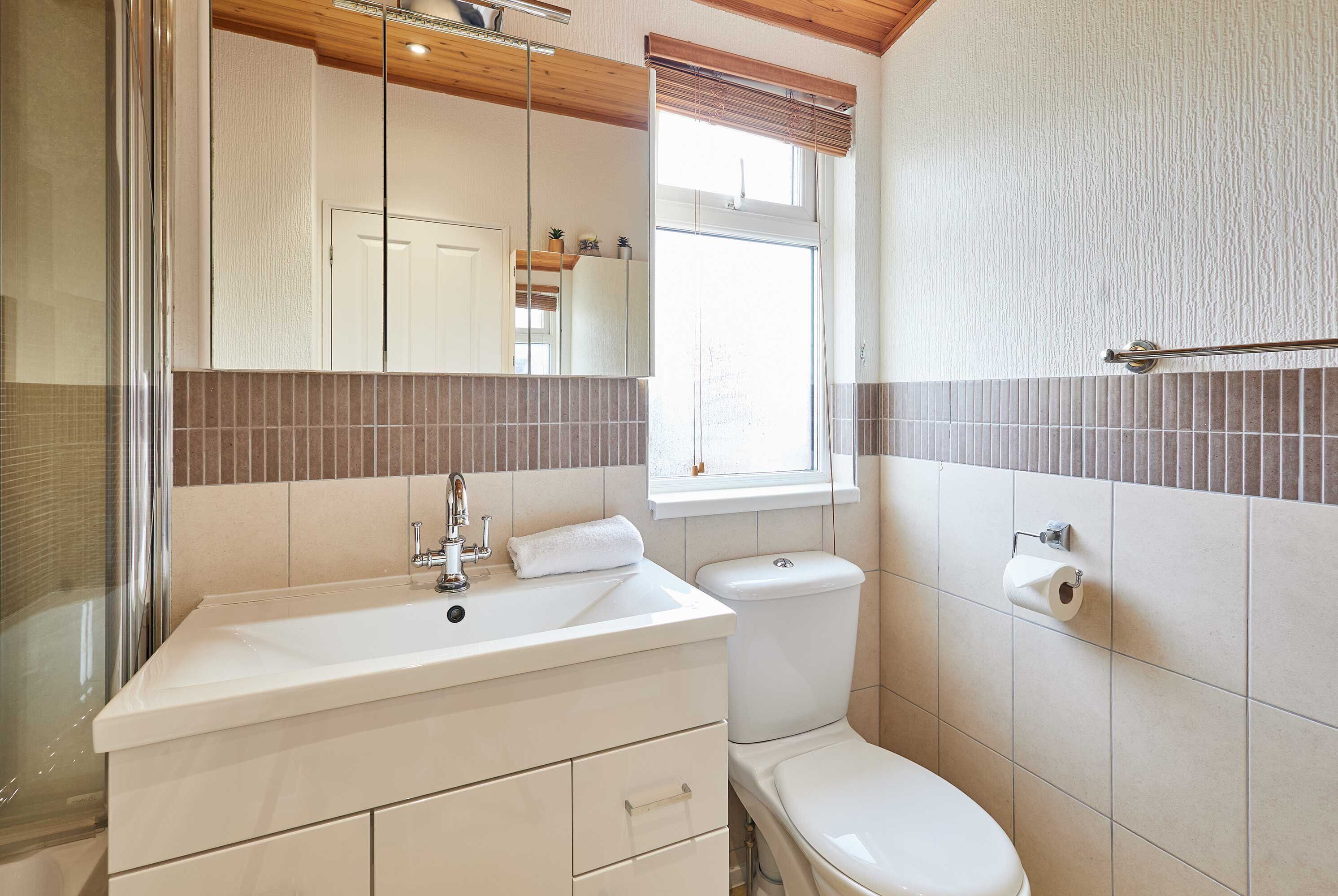 Ein Badezimmer mit Waschbecken, Spiegel und Toilette.