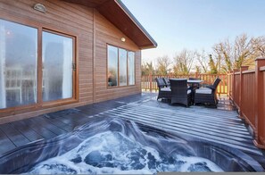 A wooden deck with a hot tub, outdoor furniture, and a wooden fence. - Host Stay Hidden Gem Lodge (Malton)