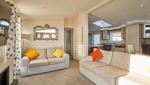 A spacious living area with two sofas, a fireplace, and a large mirror. - Host Stay Penny Lodge (York)