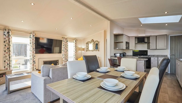 A modern living room with a dining area, kitchen, and a fireplace. - Host Stay Penny Lodge (York)