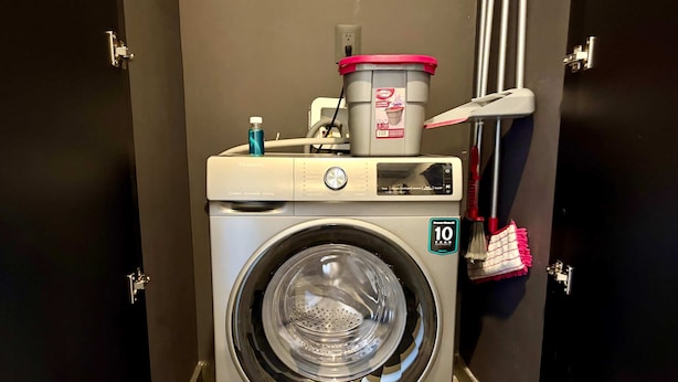 Lavadora compacta de carga frontal con una garantía de 10 años, dispensador de detergente y un tendedero para ropa.