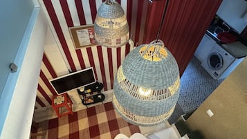 A staircase with a checkered floor, a red and white striped wall, and a hanging light fixture.