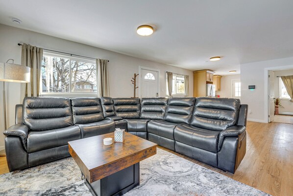 A modern living room with a sectional sofa, a wooden coffee table, and a patterned rug. - Walkable Adventure Base in Midtown Anchorage (Anchorage)