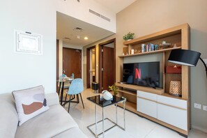Departamento Deluxe, vista a la ciudad | Área de sala de estar | Smart TV de 65 pulgadas con canales por cable y Netflix 