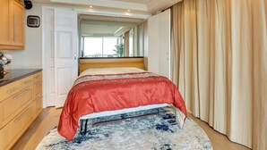 Een slaapkamer met een bed, een kledingkast, een klok en een raam.