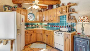 A kitchen with wooden cabinets, a white refrigerator, a stove, and a tiled backsplash. - 6 Mi to Texas Tech: Studio w/ Shared Pool & Grill (Lubbock)