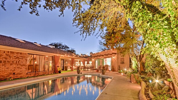A pool area with a brick building, outdoor seating, and string lights. - 6 Mi to Texas Tech: Studio w/ Shared Pool & Grill (Lubbock)