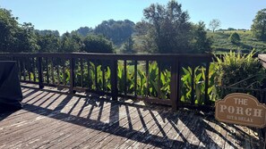 A wooden deck with a sign reading 'The Porch Sit & Relax'.