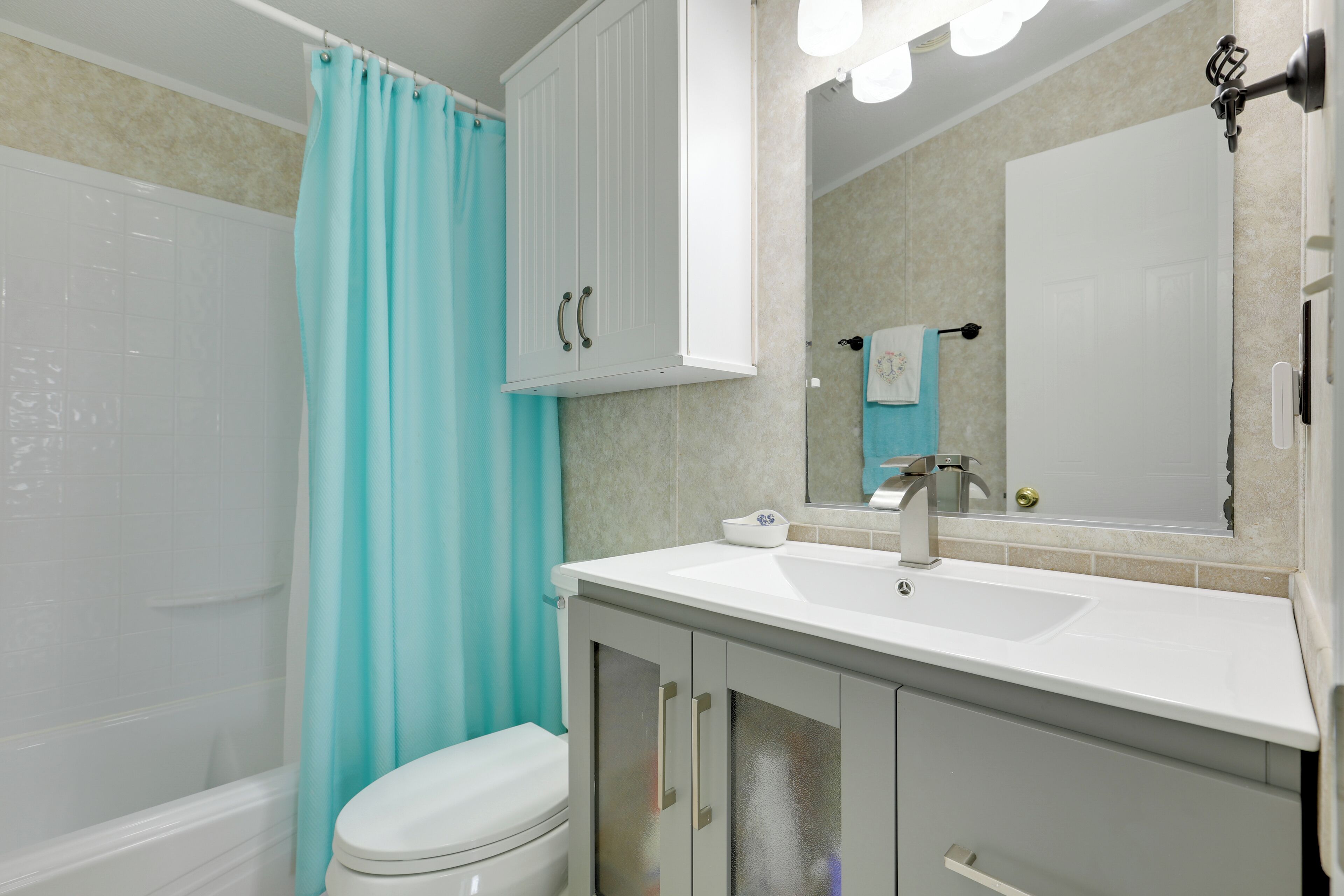 A bathroom with a white toilet, a sink, and a shower.
