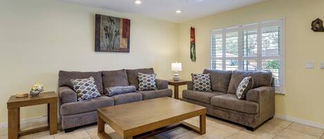 A living room with two sofas, a coffee table, and a side table.