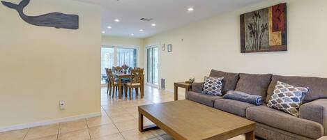 A living room with a sofa, coffee table, and a whale mural on the wall.