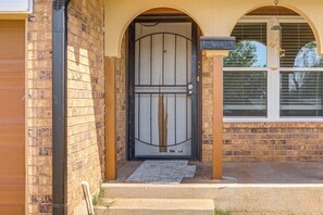 A brick house with a double door, a mailbox, and a window with blinds. - 8 Mi to Bricktown Fun: Quiet Family Retreat (Oklahoma City)