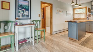 A kitchen with a wooden table, two chairs, a small island, and a window with curtains. - 'point of View' Hilltop Sanctuary in Brevard (Brevard)