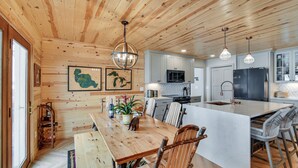 A wooden interior with a dining area, kitchen, and bar. - Luxe Hideaway on Houghton Lake: Families Welcome! (Houghton Lake)