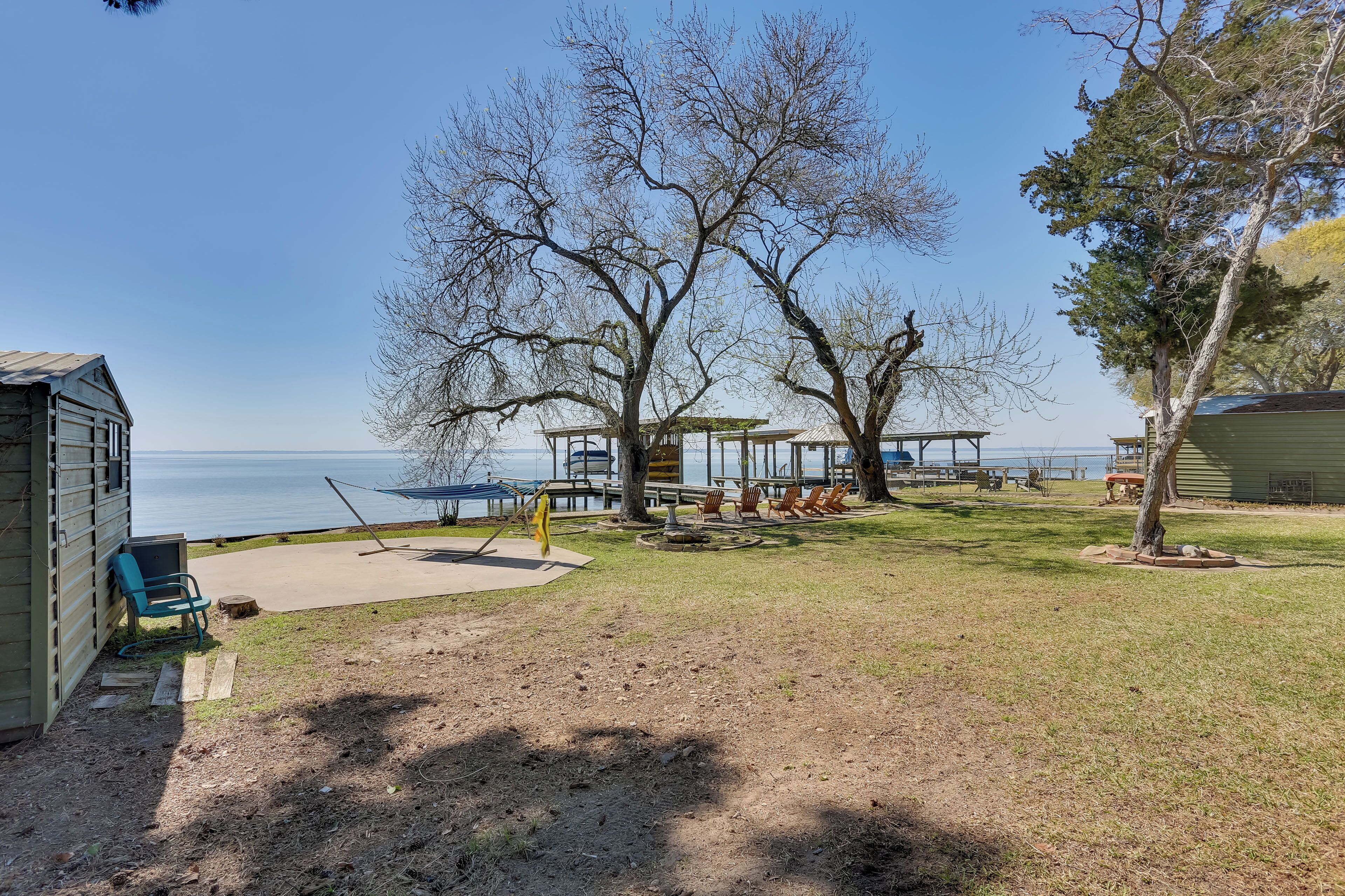 A lakeside property with a patio area, outdoor seating, and a view of the water.