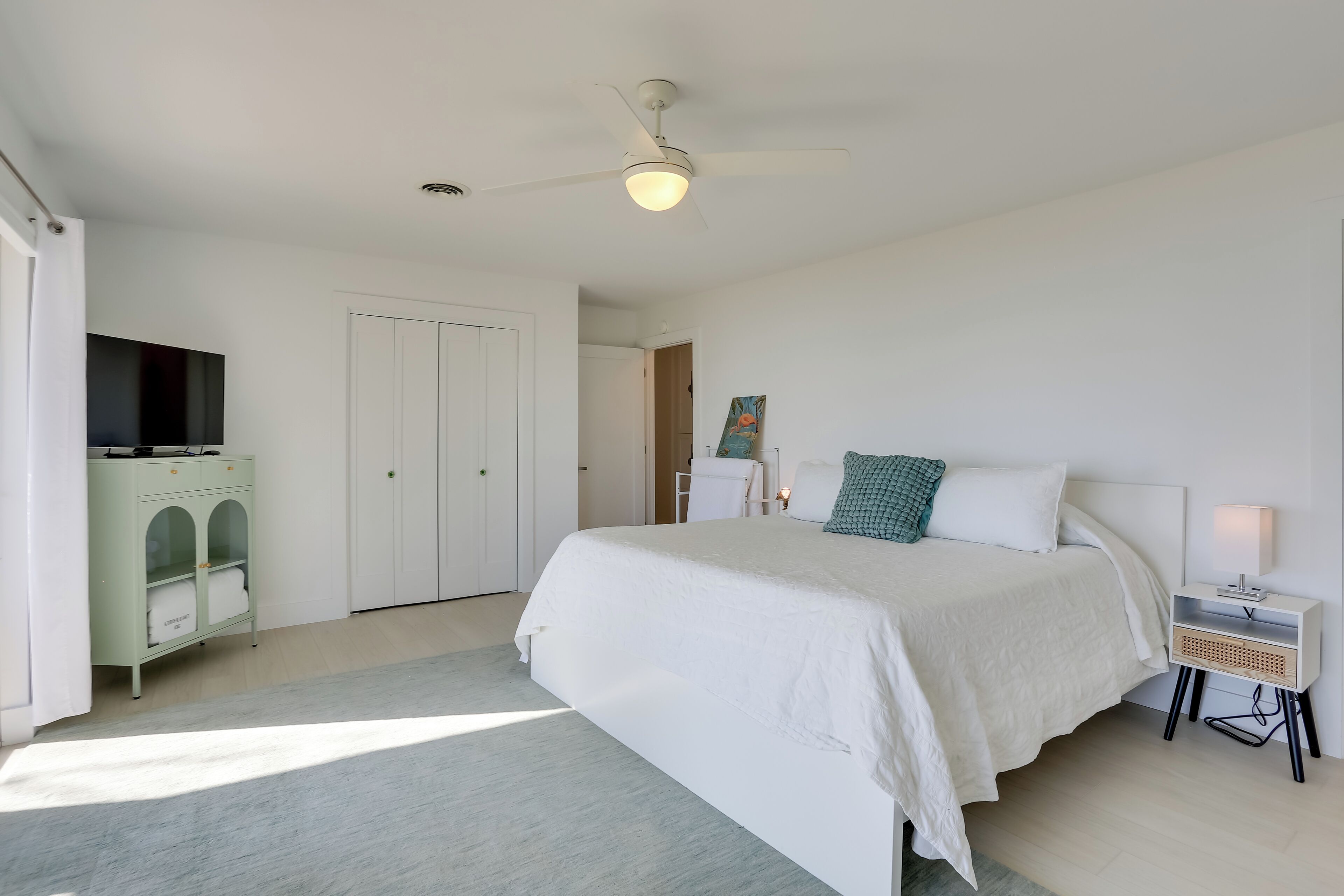 A bedroom with a bed, a nightstand, a TV, and a wardrobe.