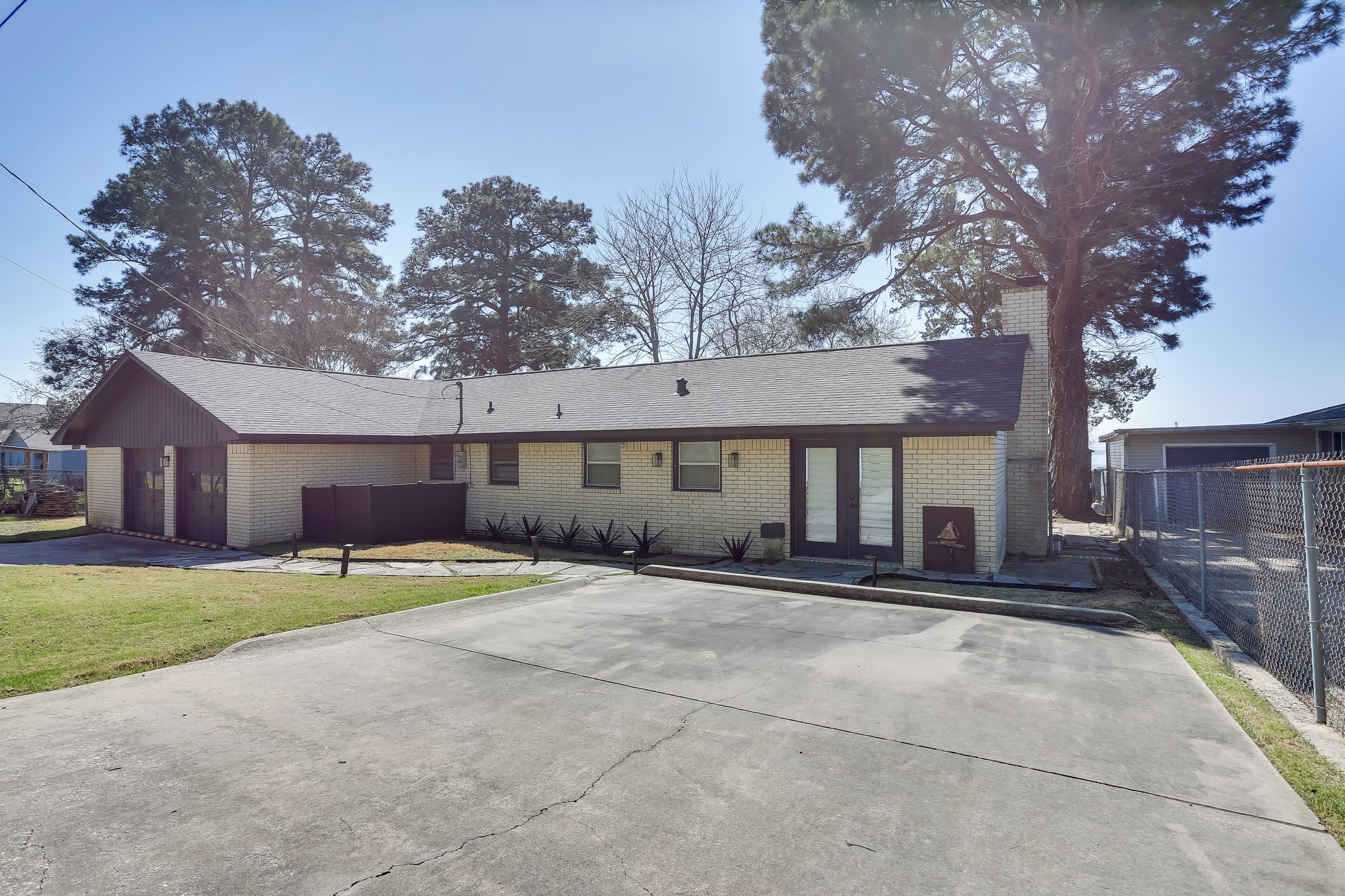 A two-story house with a front yard, a garage, and a tall tree.