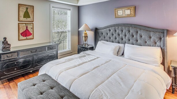 A bedroom with a large bed, a dresser, a nightstand, and a window with blinds. - Screened Porch + Pool Access: Longs Golf Getaway (Longs)