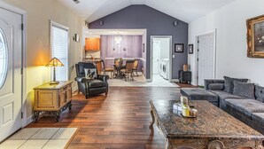A spacious living room with a high ceiling, a dining area with a chandelier, and a laundry room with a washing machine. - Screened Porch + Pool Access: Longs Golf Getaway (Longs)