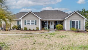 A two-story house with a front porch, a garage, and a well-maintained lawn. - Screened Porch + Pool Access: Longs Golf Getaway (Longs)