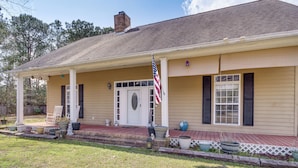 A two-story house with a front porch, a flag, and a mailbox. - Explore Gulf Coast & Beyond! Home w/ Yard & Games (Long Beach)