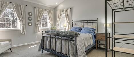 Un dormitorio con cama, mesita de noche, cómoda y estantería empotrada.