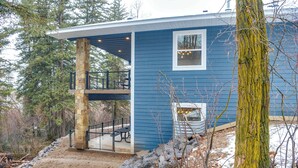 A two-story house with a stone pillar, a covered deck, and a small window. - Covered Patio, Creek & Mtn Views: Afton Nature Hub (Afton)