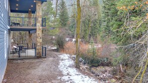 A two-story building with a stone exterior and a balcony with outdoor furniture. - Covered Patio, Creek & Mtn Views: Afton Nature Hub (Afton)