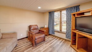A living room with a leather chair, wooden entertainment center, and a TV. - 4 Mi to Gauley River Rapids! Outdoor Adventure Hub (Summersville)