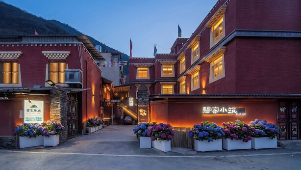 Un edificio tradicional con un cartel que dice 'BIJIA INN' y una escalera que lleva a un nivel superior.