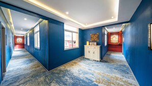 Un pasillo con paredes azules, un armario blanco y un suelo estampado.