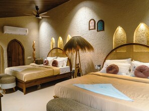 A room with two beds, a ceiling fan, a wall-mounted air conditioner, and a decorative lamp. - Hidden Beach Resort by Greenleaf Aqua (Karjat)