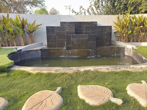 A garden with a pond, stone steps, and leaf-shaped stepping stones. - Hidden Beach Resort by Greenleaf Aqua (Karjat)