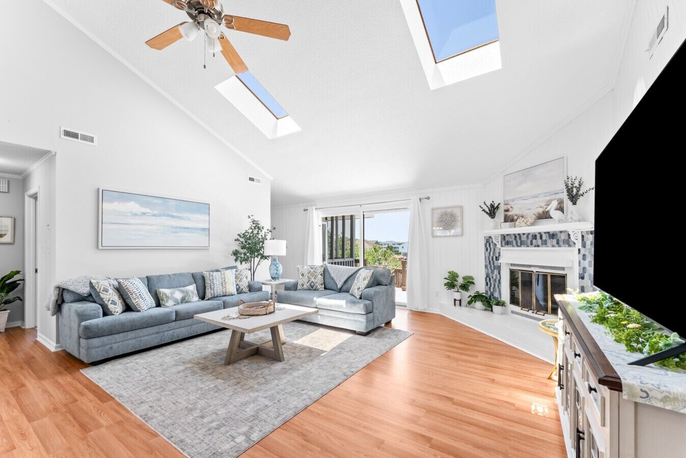 A spacious living room with a large sofa, a coffee table, and a fireplace.