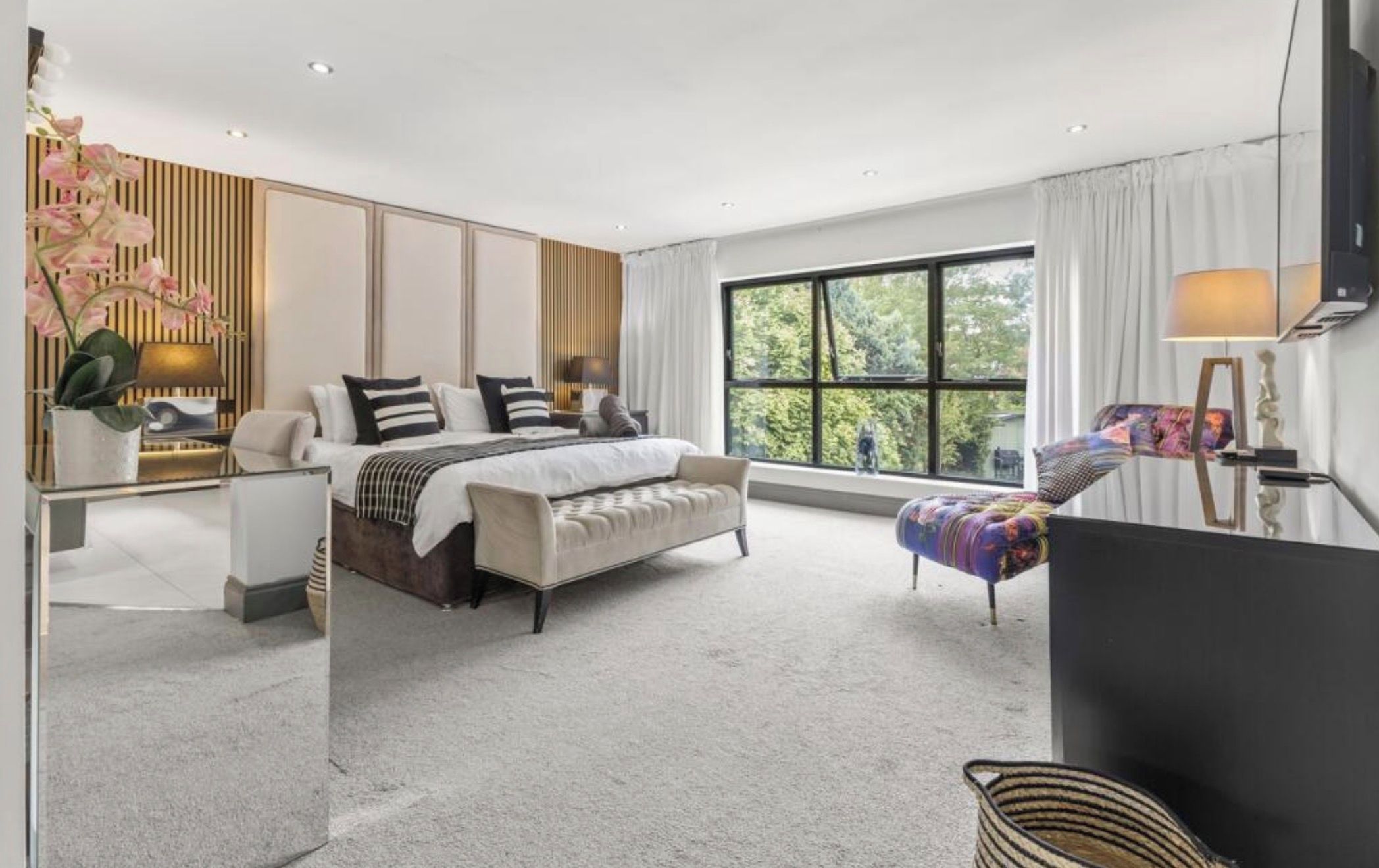 Une chambre moderne dotée d’un grand lit, d’un coin salon et d’une fenêtre offrant une belle vue.