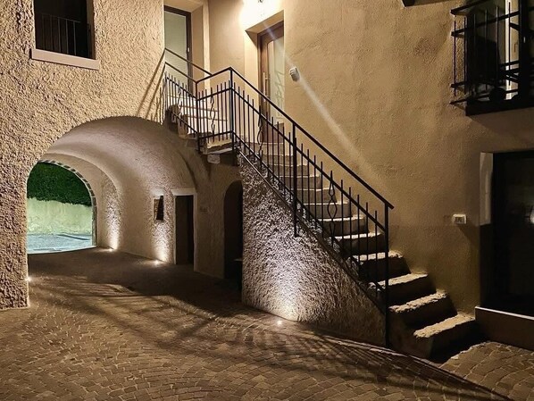 Un escalier en pierre menant à l’étage supérieur, avec un petit palier et une porte en haut.