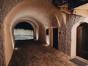 A tunnel-like passageway with stone walls and a brick floor, leading to a dark opening. - Villetta Moscal- Bella Vista (Affi)