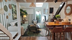 Een modern interieur met een trap, een eethoek en een woonkamer met gestreepte wanden en decoratieve objecten.