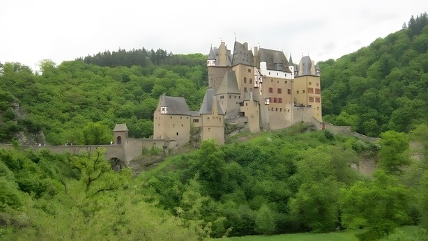 Un castillo en una colina con múltiples torres y una muralla fortificada.