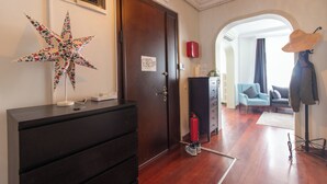 A hotel lobby with a wooden desk, a star decoration, a door, a fire extinguisher, and a coat rack. - Cozy 3BR Apartment in Şişli Close to Cevahir Mall (İstanbul)