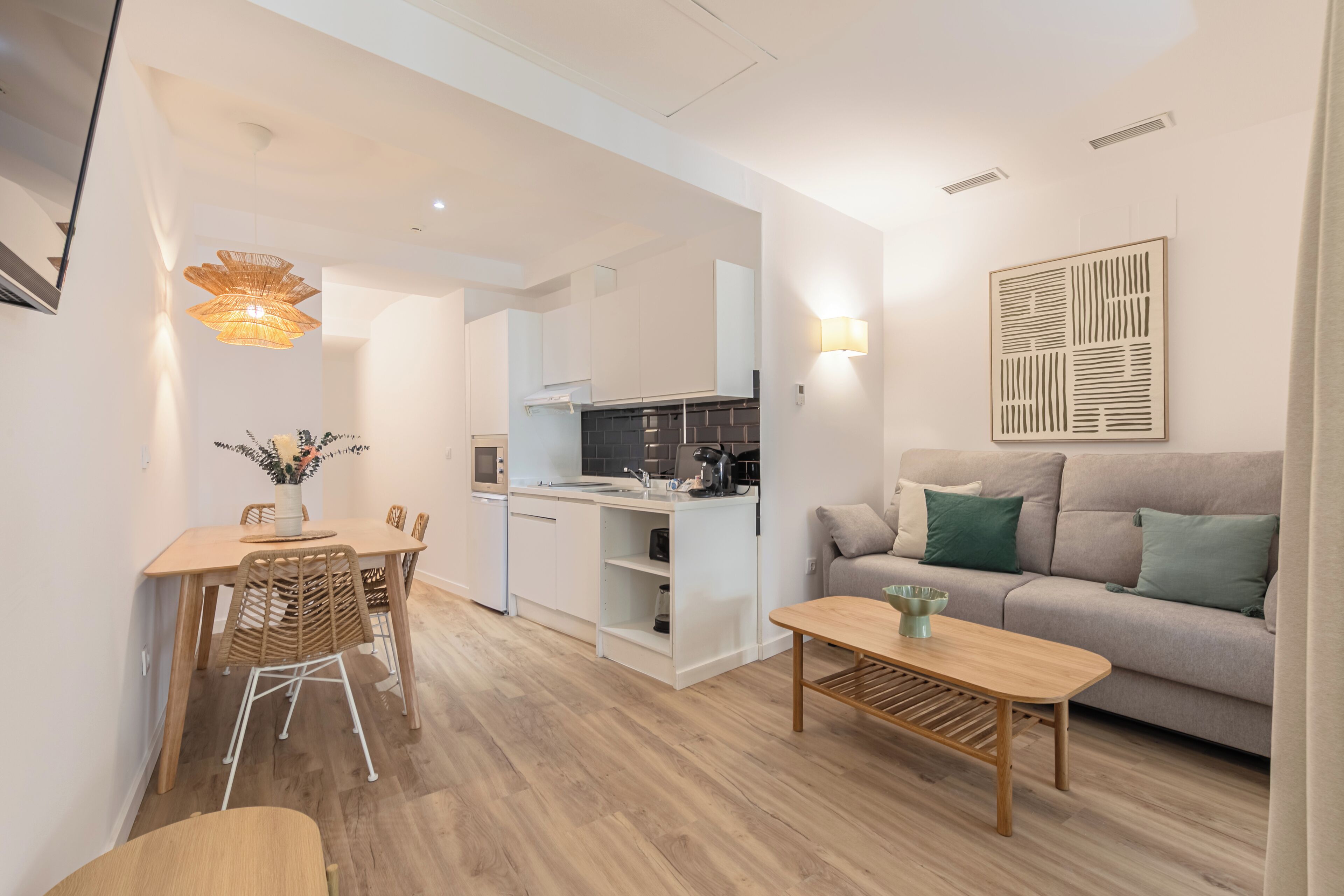 Un espace de vie moderne comprenant un coin repas, une cuisine et un coin salon.