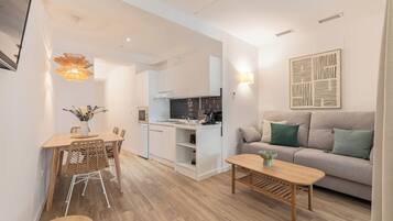 A modern living space with a dining area, kitchen, and seating area.