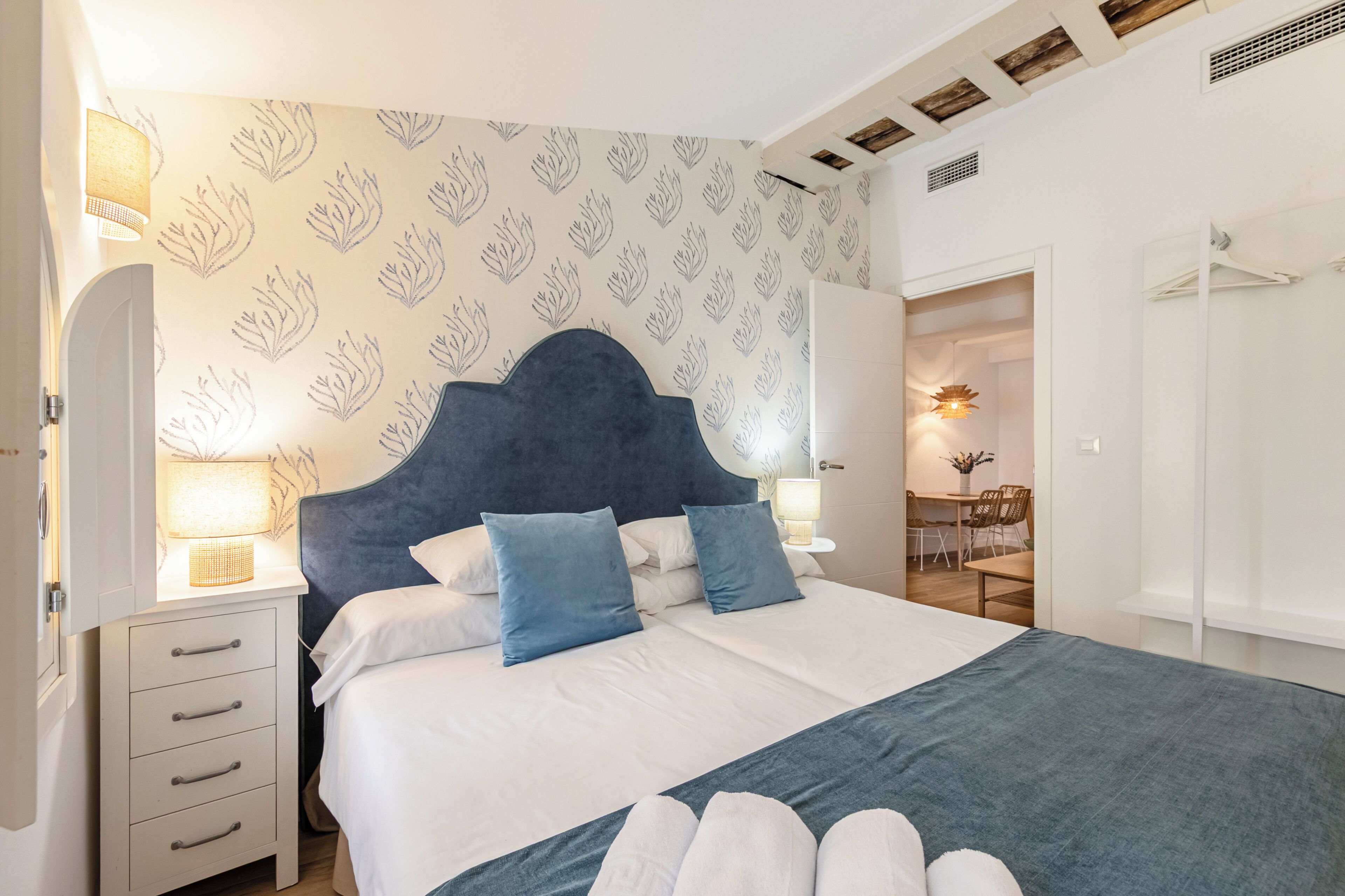 A bedroom with a bed, bedside tables, a dresser, a desk, and a chair.
