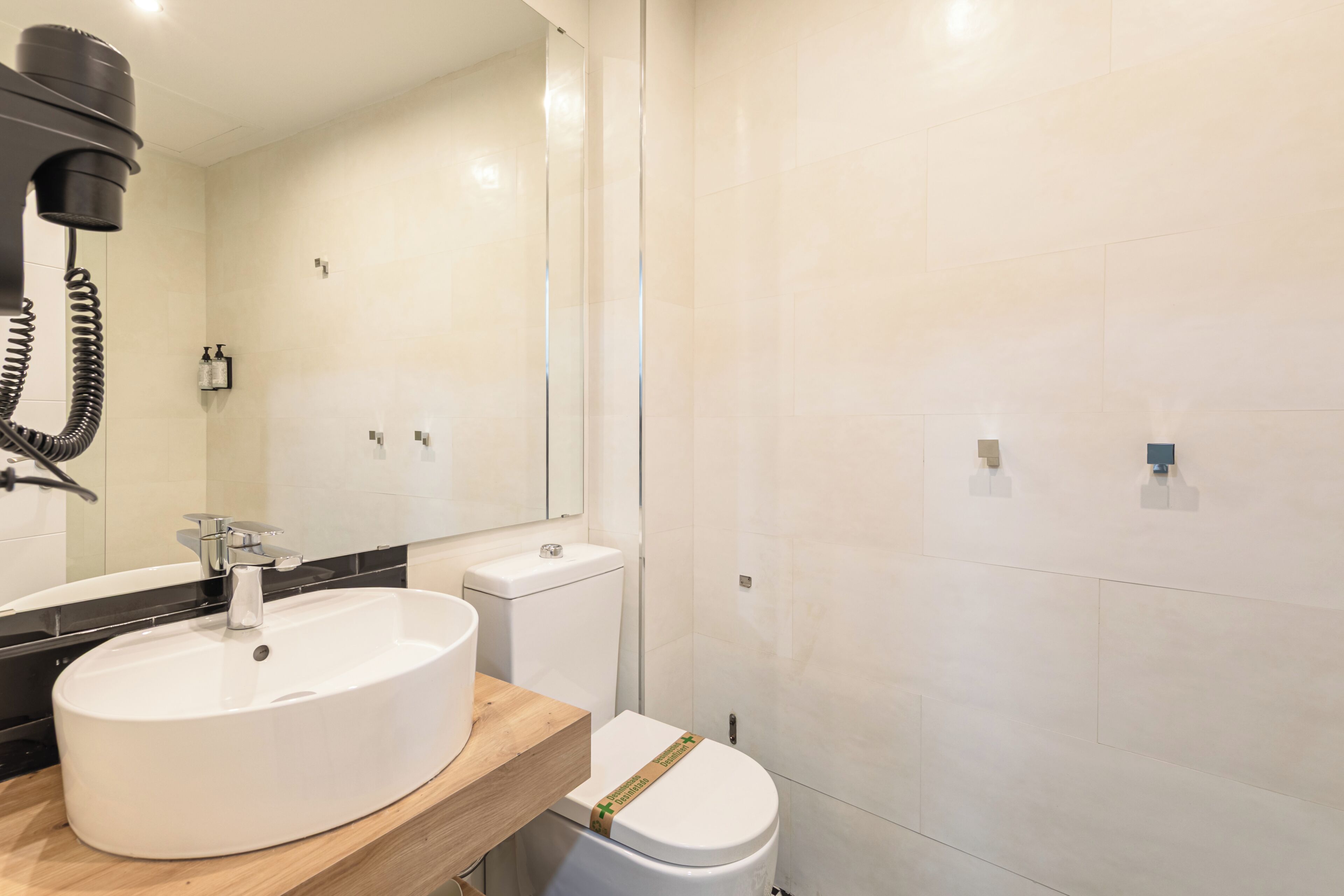 A modern bathroom with a white sink, toilet, and shower.