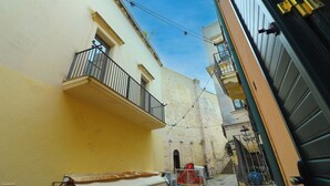 A narrow urban street with buildings on either side, featuring balconies and a clear sky. - Beautiful private villa for 4 people with A/C, WIFI, TV and panoramic view (Otranto)
