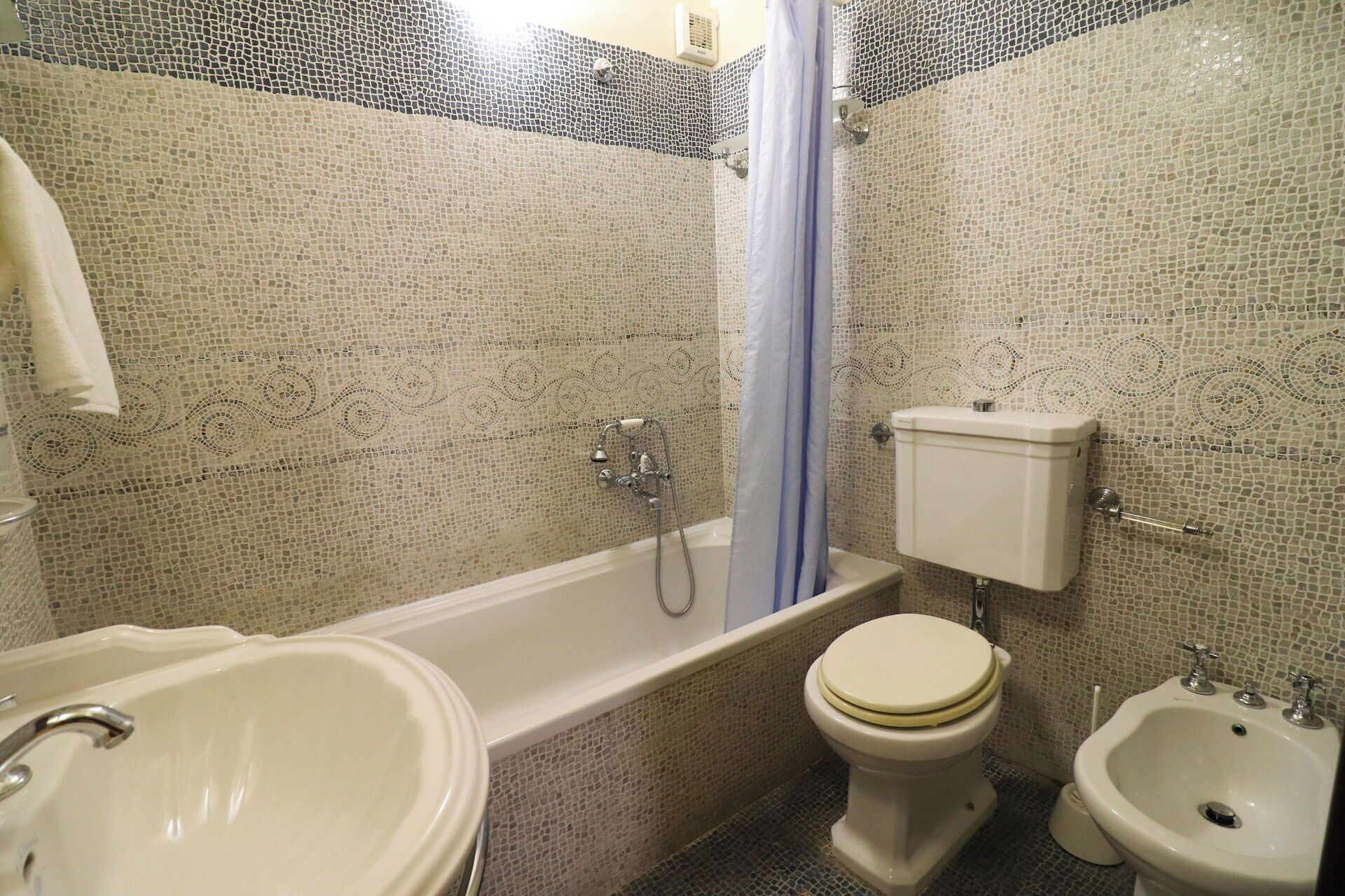 Un baño con bañera, inodoro, bidé y lavabo.