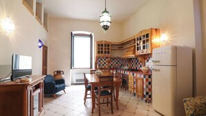 A kitchen with a tiled floor, wooden cabinets, a refrigerator, and a dining table with chairs. - Beautiful private villa for 4 people with A/C, WIFI, TV and panoramic view (Otranto)