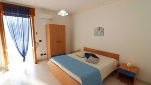 A bedroom with a bed, nightstand, wardrobe, and a window with blue curtains. - Wonderful  villa for 8 guests with A/C, WIFI, TV and balcony (Otranto)